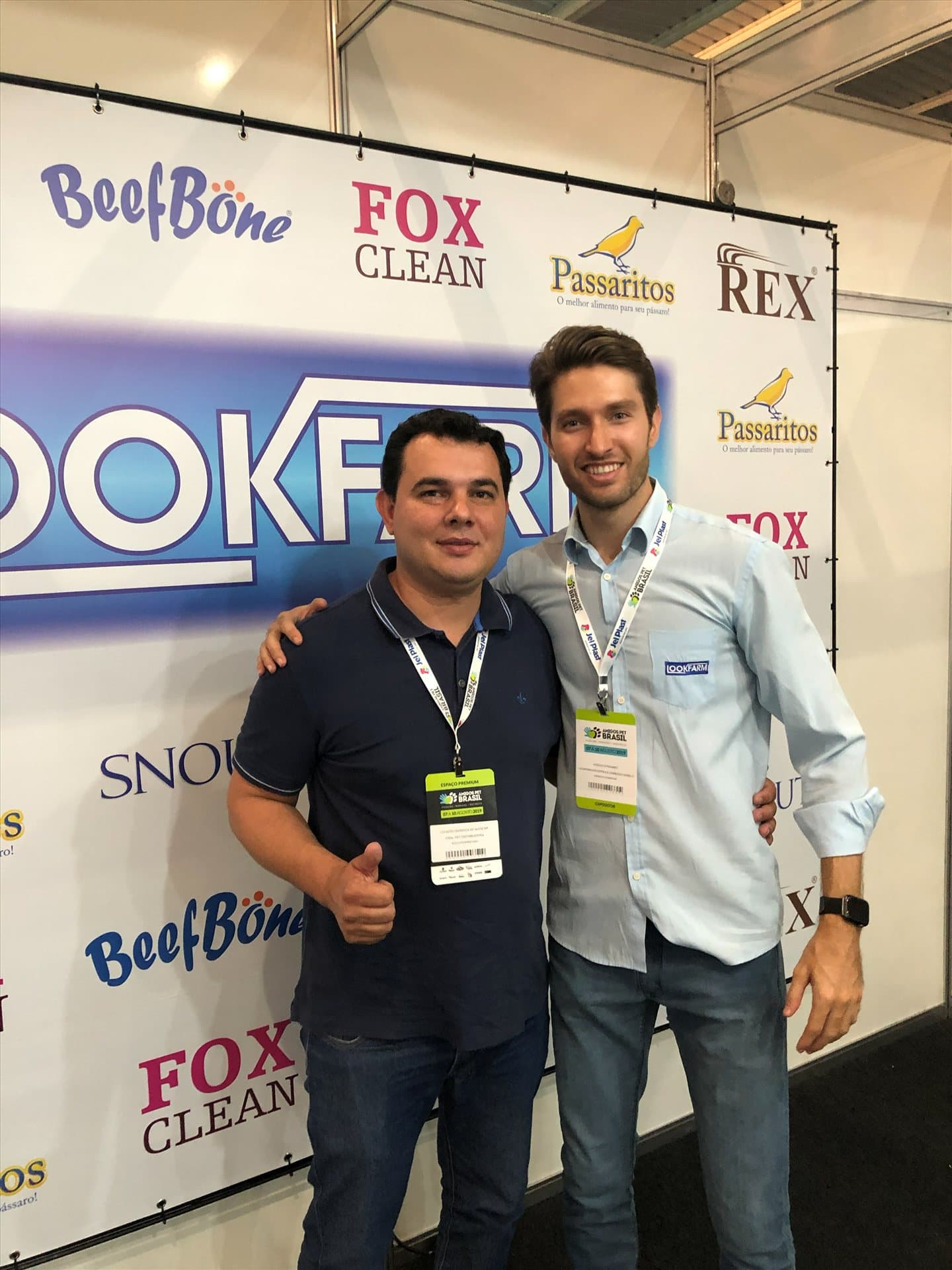 Equipe Lookfarm em frente ao painel da marca no estande